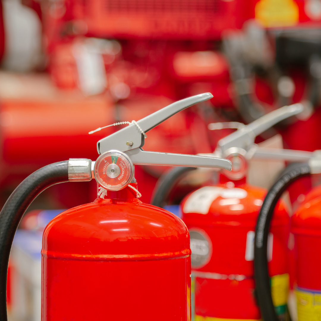 A close-up of red fire extinguishers, highlighting their nozzles and safety mechanisms.