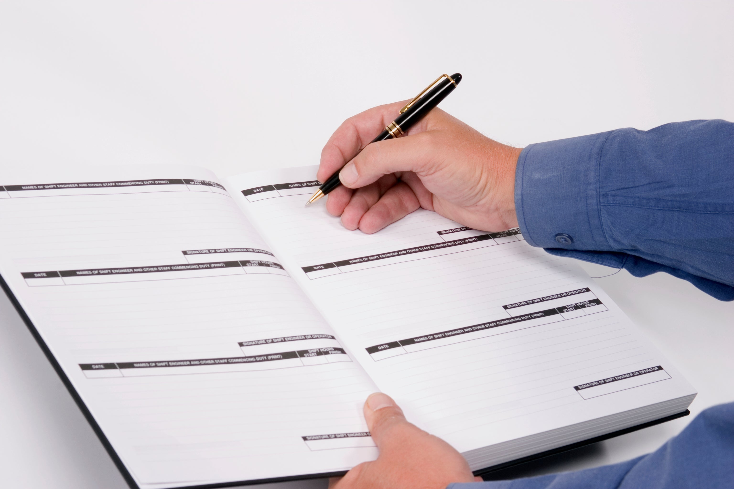 a person's hand writing into a log book