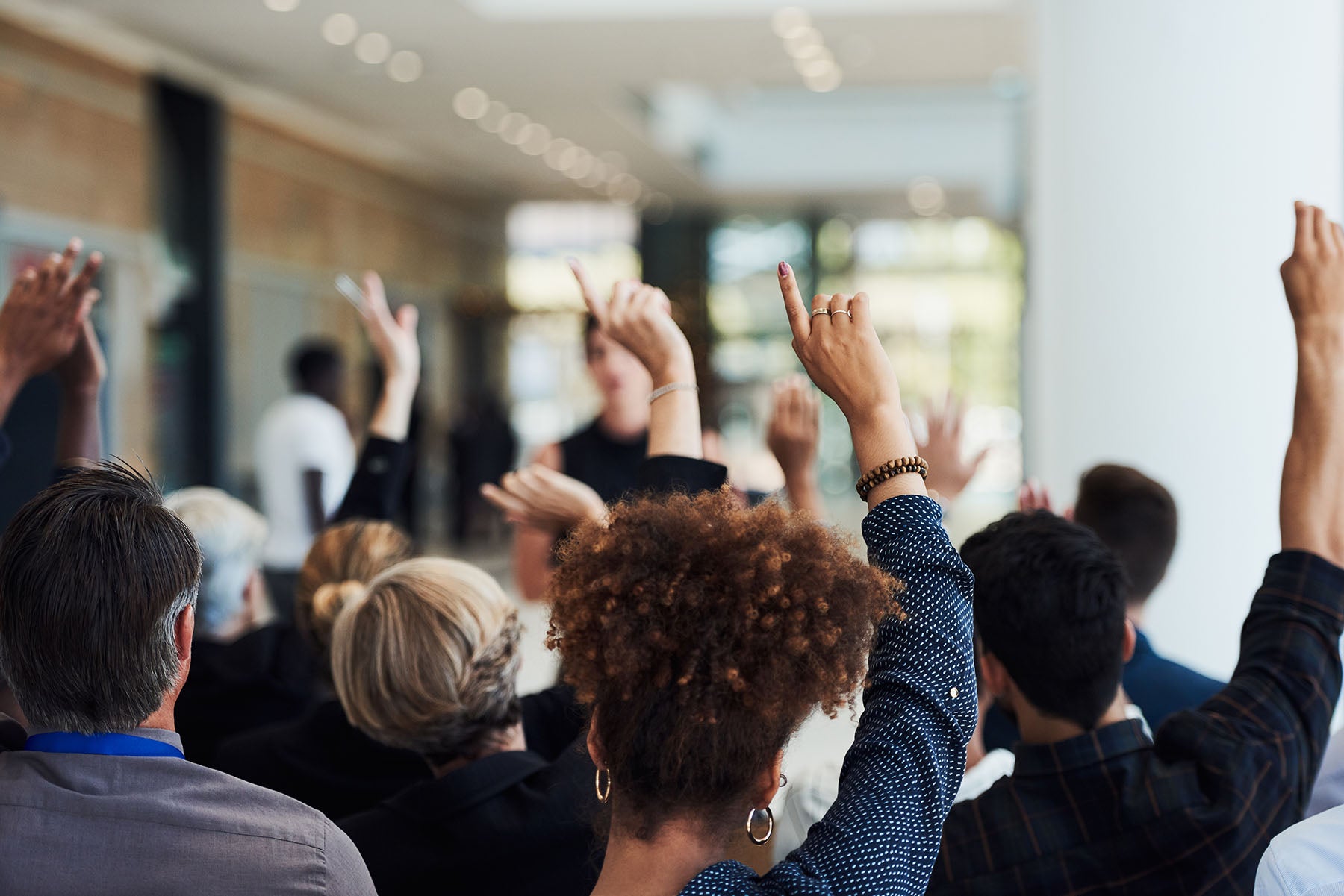 a group of people with their hands up asking questions