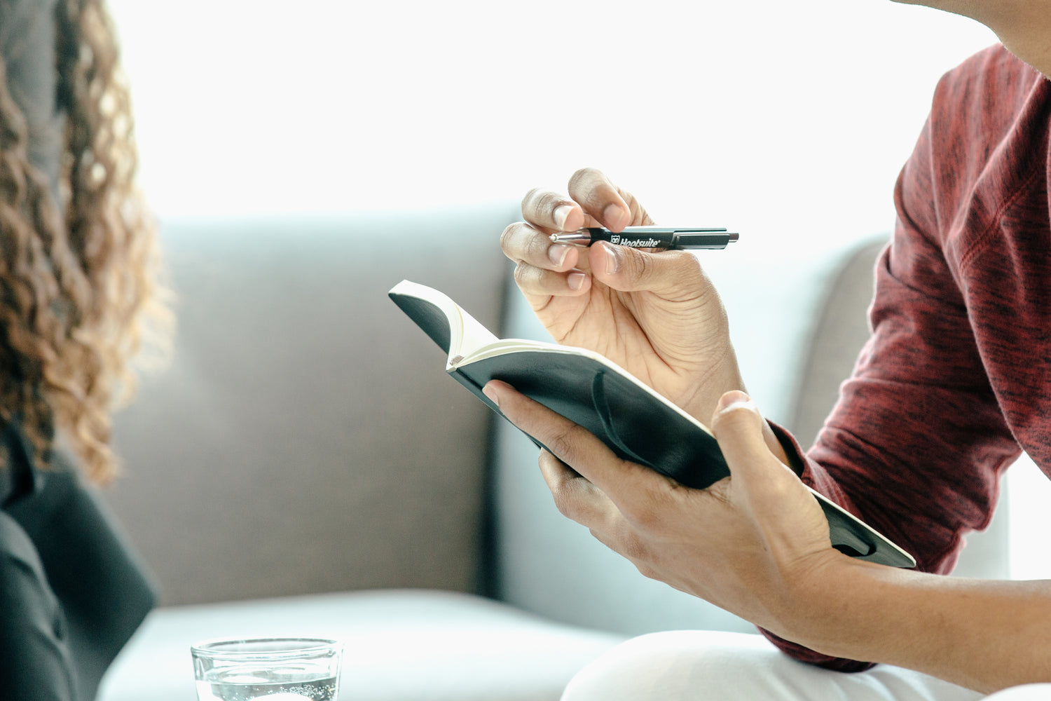 a person holding a notebook and a pen. They are about to start writing.