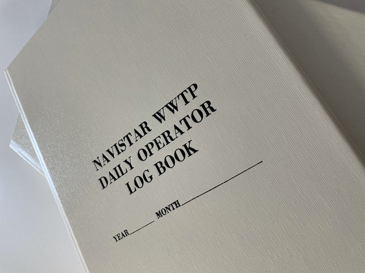 a white custom log book with a hard cover and black text.