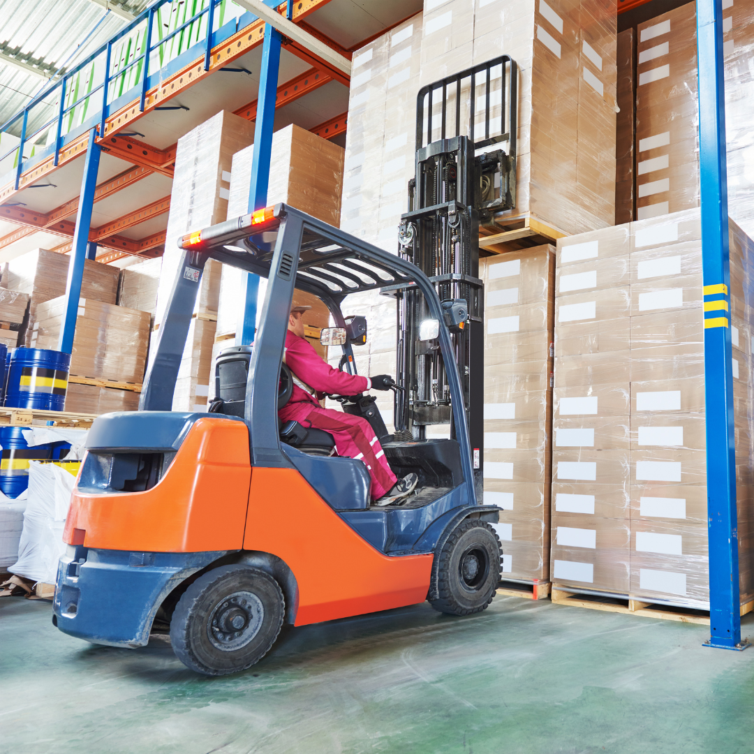 A forklift in a warehouse, lifting boxes stacked on shelves.